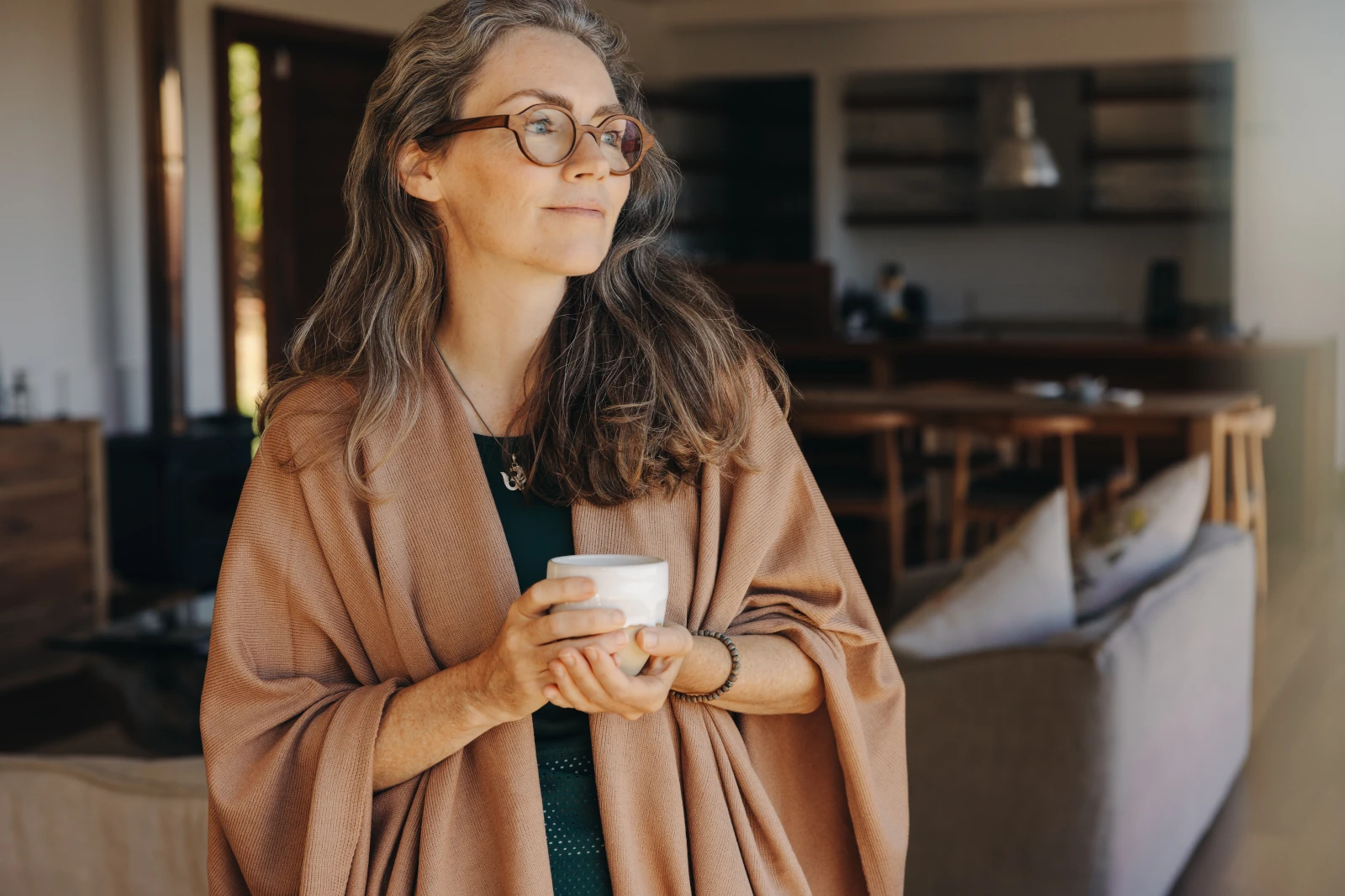 Woman holding a coffee cup, looking into the distance