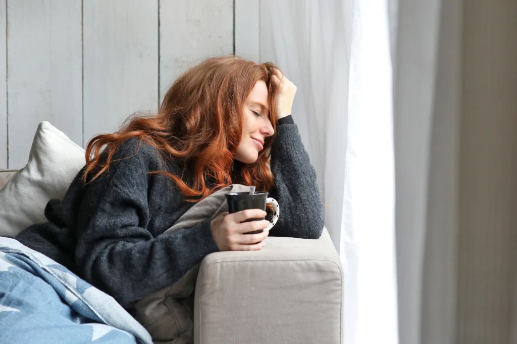 Young woman with coffee cup on the sofa