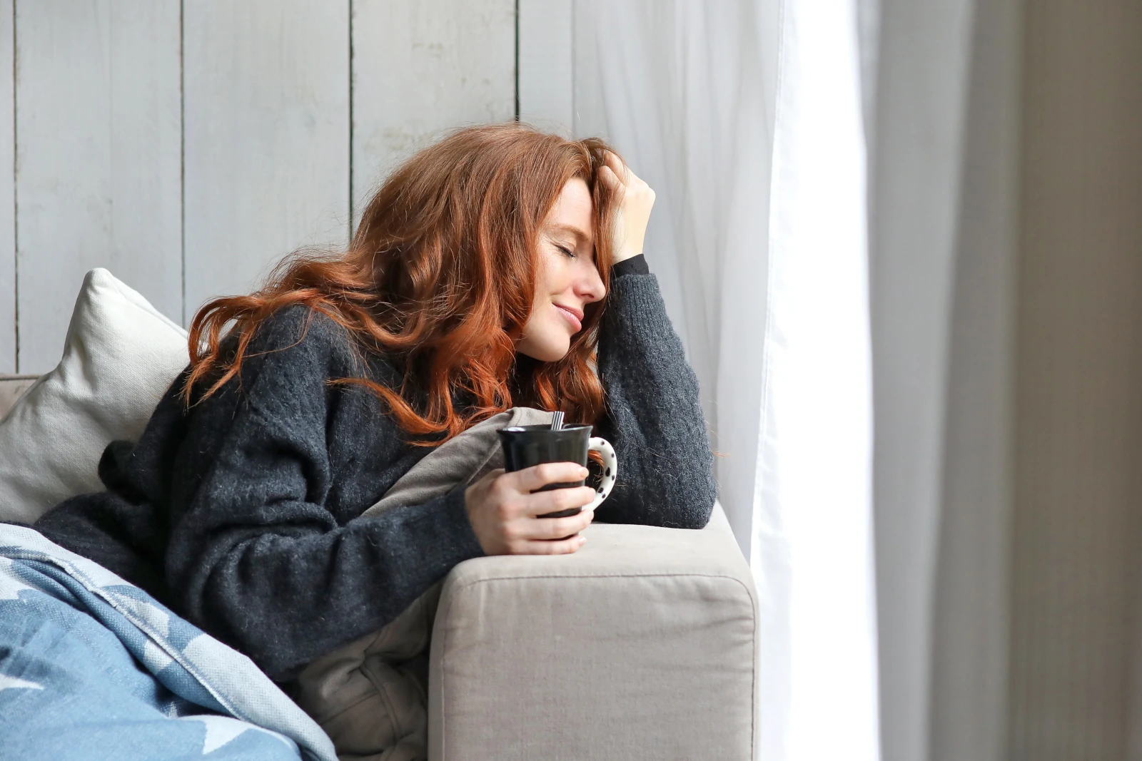 Young woman with coffee cup on the sofa